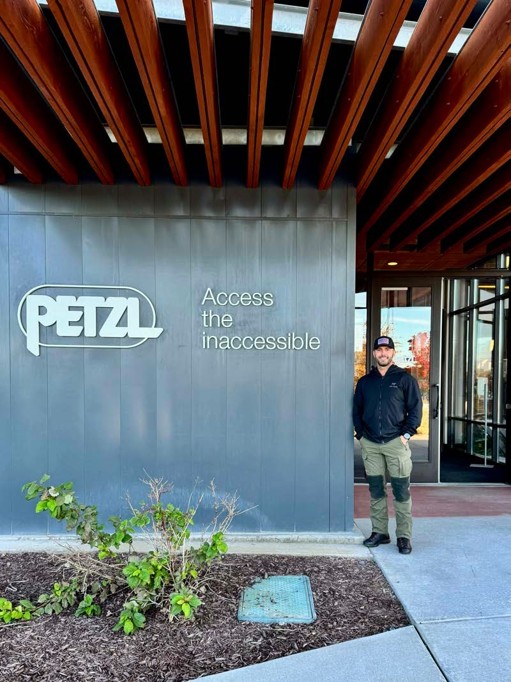 man in front of a building sign "access the inaccessible"